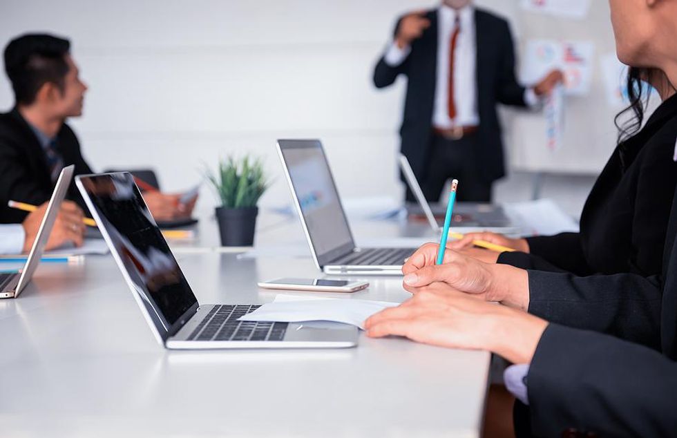 Man takes notes during staff training and development meeting