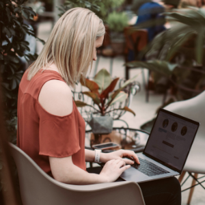 Woman viewing the Data Science with Python and learning Python data science on a laptop outdoors