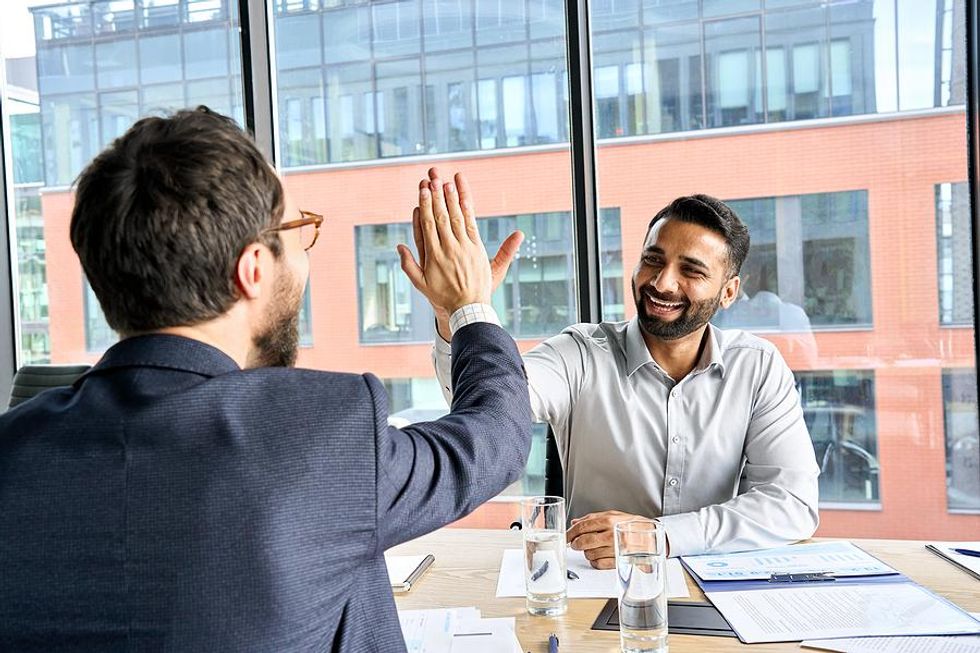 Happy man gets a high five from a coworker