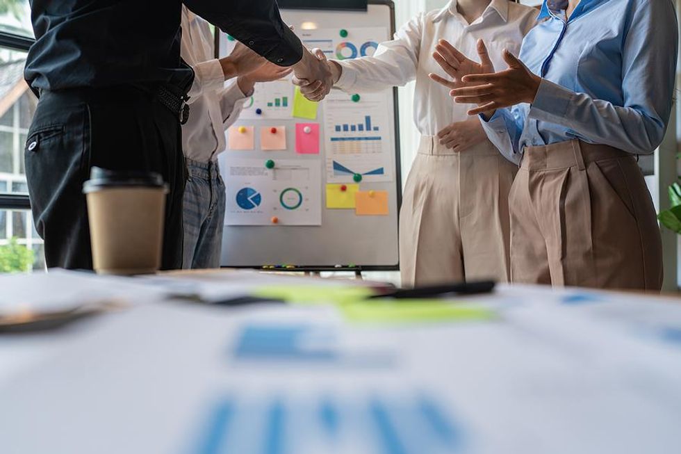 Team members shake hands after a work meeting