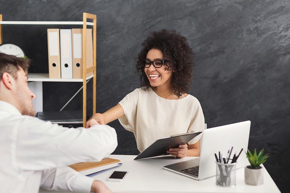 Hiring manager shakes hands with a job candidate at the end of an interview